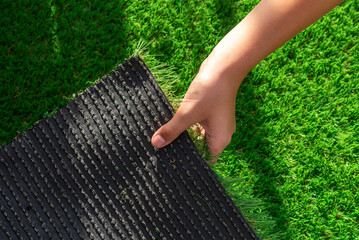 Close-up of the back of a roll of artificial turf. Synthetic artificial grass material easy to...