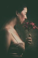 portrait of beautiful woman smelling a bouquet of lilies VI