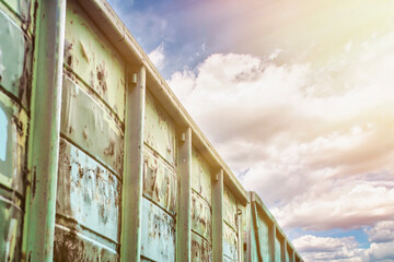 Close-up of a part of the body of a freight railway car against a blue sky.
