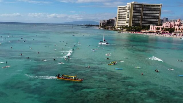 Drone view of the outrigger and surfers in sea at the Waikiki Beach
