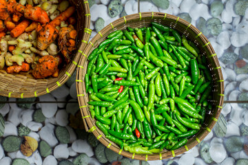 fresh green chilies in traditional bamboo basket