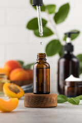 A drop of skin care serum is dripping from a pipette into a bottle. Oil with apricot kernel extract...