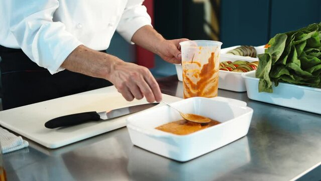 Professional restaurant kitchen, close-up: the sauce is applied to a baking sheet