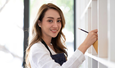 Portrait of Asian young woman SME working with a box at home the workplace.start-up small business owner, small business entrepreneur SME or freelance business online and delivery concept.