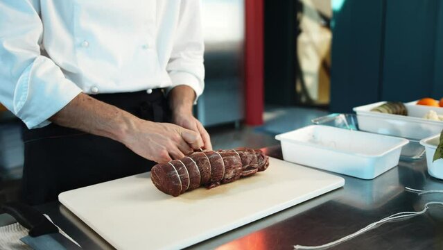 Close-up: The chef cuts the meat of the filet mignon with a knife. The process of preparing food with a restaurant.