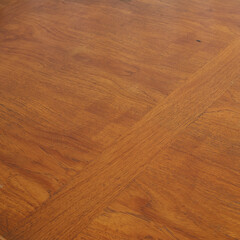 Rich brown teak mid-century modern dining room table. Table surface close-up detail with wood grain.