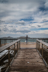 Obraz premium junge Frau bei stürmischen Wetter auf Aussichtsplattform über Meer