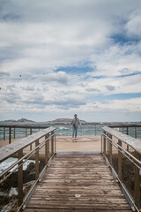 Obraz premium junge Frau bei stürmischen Wetter auf Aussichtsplattform über Meer