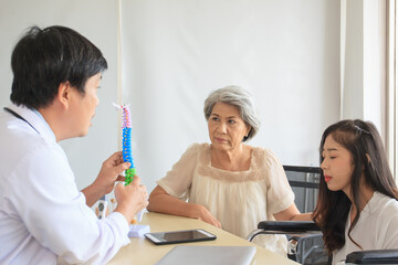 Fototapeta premium Asian young woman and her mother talking having a consulting with orthopedic doctor.