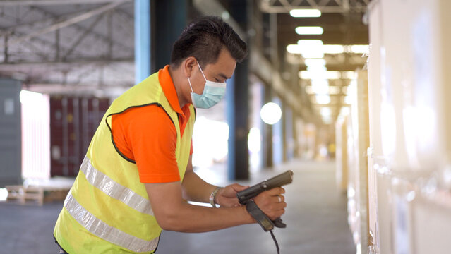 Asian senior warehouse staff using the barcode reader scanning or checking for stock inventory in warehouse.
