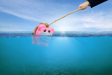 Financial Aid and rescue from debt problems for investments above water as a drowning pink piggy...