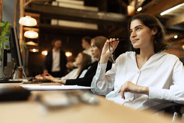 Delightful woman, manager at the office after finishing new project.