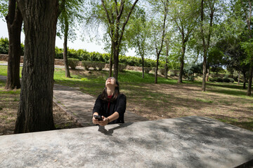 Brunette woman with black jacket reading WhatsApp and laughing out loud