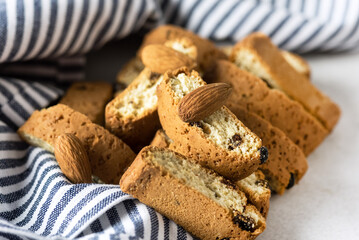 Italian Cantuccini Cookies Sweet Dried Biscuits with Nuts and Raisin Blue Napkin Gray Background Horizontal
