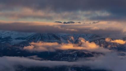 Colorful winter sunset in the Alps, above the inversion and clouds