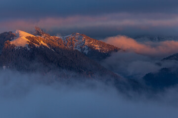 Fototapeta na wymiar Colorful winter sunset in the Alps, above the inversion and clouds
