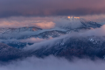 Colorful winter sunset in the Alps, above the inversion and clouds