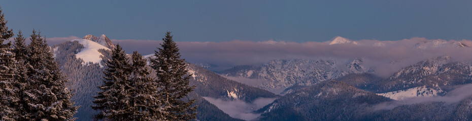 Colorful winter sunset panorama  in the Alps, above the inversion and clouds