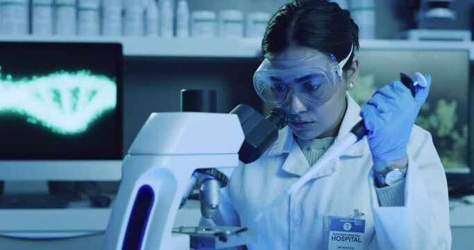 Female scientist, experiment and analyze in forensic science. Woman conducting new research, running tests for new discoveries. Lady experimenting with particles under a microscope in a lab.