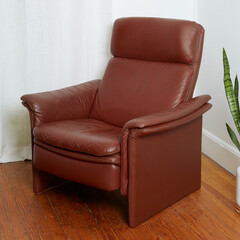 Vintage minimal top grain oxblood leather recliner. Postmodern 1980s stylish chair. Side view in...