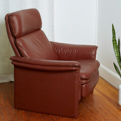 Vintage minimal top grain oxblood leather recliner. Postmodern 1980s stylish chair. Side view in...