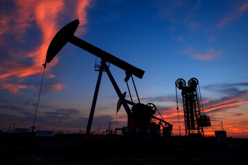 The pumpjack is working at sunset
