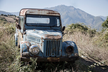 Obraz na płótnie Canvas Old rusty blue truck for transporting food or animals in the Greek mountains