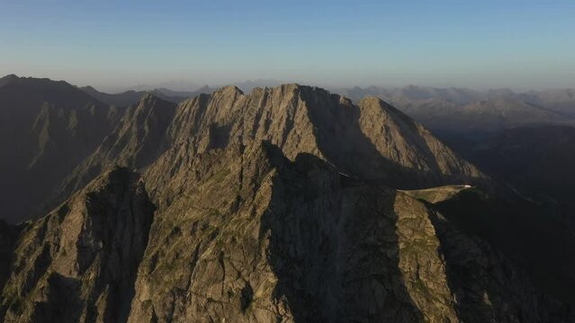 Drohenflug im Wandergebiet Meran 2000. Drohne bei Sonnenuntergang am Infinger mit Blick auf das Gipfelkreuz. Sarntaler Alpen 2
