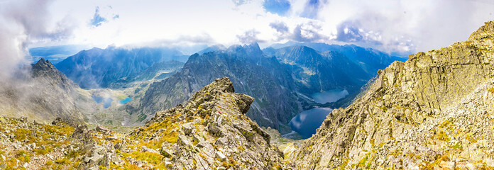 High Tatras mountains panorama. View from mt Rysy (2503m) on the border between Slovakia (left) and Poland (right). Zabie lakes (Slovakia) and Morskie Oko lake (Poland) on background - obrazy, fototapety, plakaty