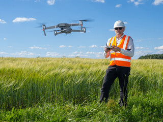 Geodetic technologies. Man surveyor next to green field. Geodetic survey with help of drone....
