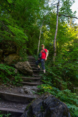 Obraz premium Wanderer auf dem Weg durch die Bürser Schlucht, Mann auf dem schmalen Wanderweg über Treppen und Stufen durch die bewaldete Schlucht bei Bürs, Vorarlberg, Österreich