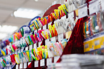 rack with different multicolored pens in stationery store.