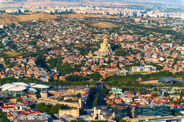 Aerial view of Tbilisi Old Town cityscape with ancient houses,  trees and  Kura river, Georgia,...