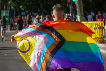 Guy with a flag back view at pride parade, march, festival. Outdoor event celebrating lesbian, gay,...