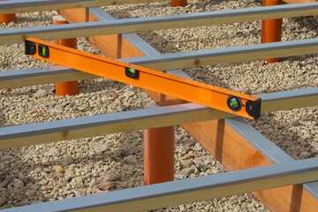 orange level. Checking the horizon of the structure with a building level. Selective focus.