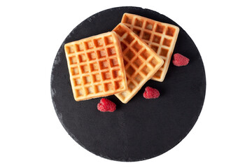 Homemade waffles with berries on black stone plate isolated. Belgian waffle with fruit raspberry on white background. Top view.