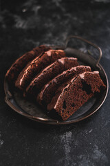 Homemade chocolate cake on dark background. Tasty brownies on plate. Double chocolate pastry. Delicious vegetarian dessert. Gluten free bakery. Selective focus. 