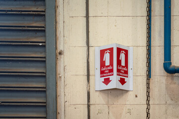 Fire extinguisher label sign which is installed on building wall. Emergency equipment symbol object...