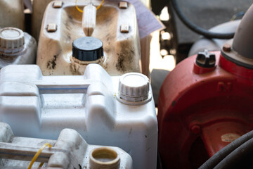 A chemical or fuel oil gallon which is stored at the factory warehouse area. Industrial equipment object, close-up and selective focus at the bottle's cap.