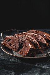 Homemade chocolate cake on dark background. Tasty brownies on plate. Double chocolate pastry....