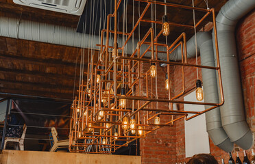 Modern loft lamp made of copper pipes in a cafe