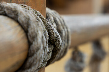 A detail of wooden railing fastened with a rope