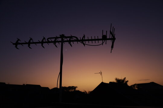 television antenna on the roof of the house.  Silhouettes of different television antennas.  silhouette of tv antenna on sunrise background.  Television roof antenna.  Technology.