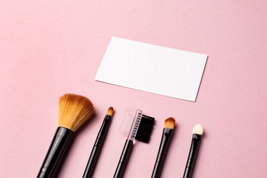 Makeup Brush And White Business Card On Pink Background. A Horizontal Template For A Makeup Artist's Business Card Or Flyer Design, With Copy Space