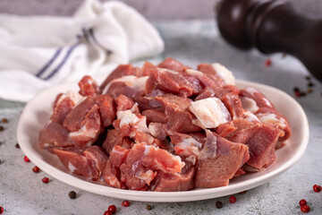 Lamb cubed meat. Chopped red meat in a plate on a stone floor. Butcher products. close up