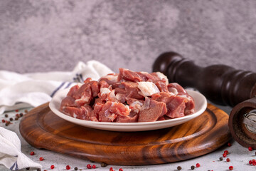 Lamb cubed meat. Chopped red meat in a plate on a stone floor. Butcher products. close up