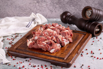 Lamb cubed meat. Chopped red meat in a wooden serving dish on a stone background. Butcher products. close up