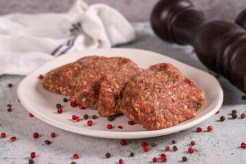 Uncooked spicy grilled meatballs. Meatballs in a plate on a stone background. close up