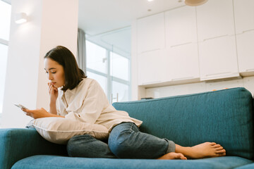 Young cute asian girl with phone scrolling social media