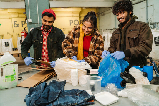 Young indian men and women working in recycling center